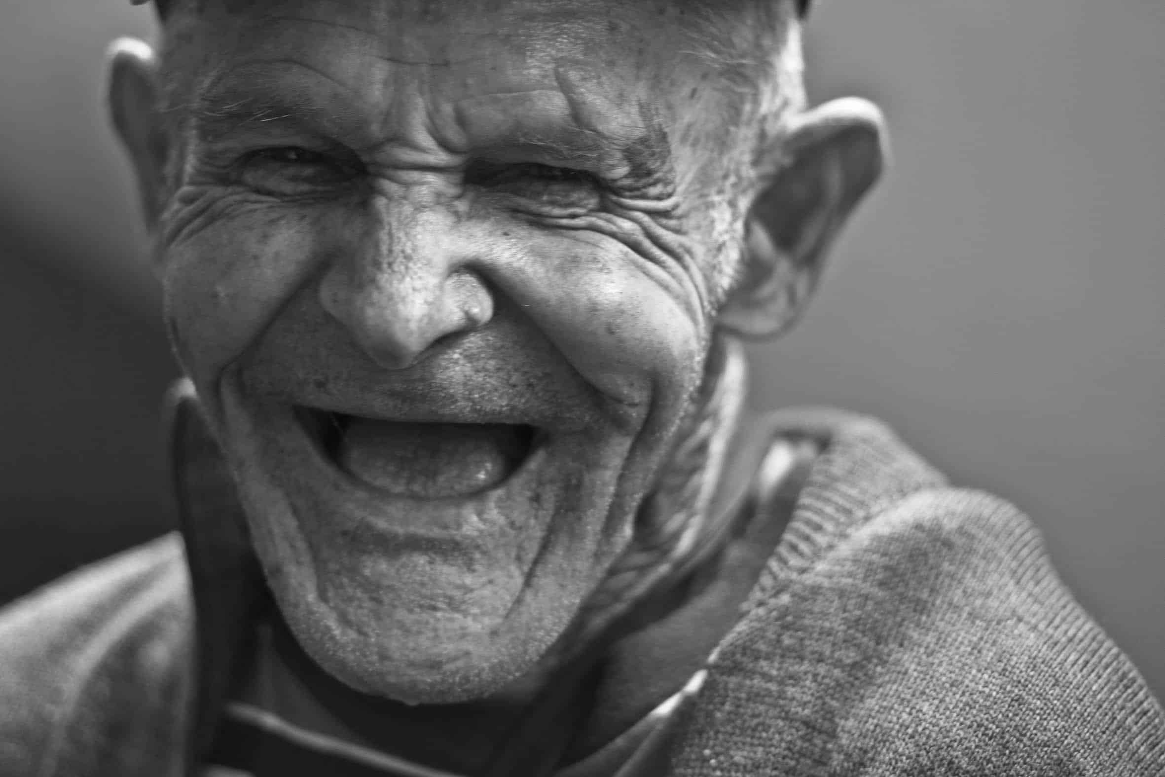 Old white man with no teeth laughing.