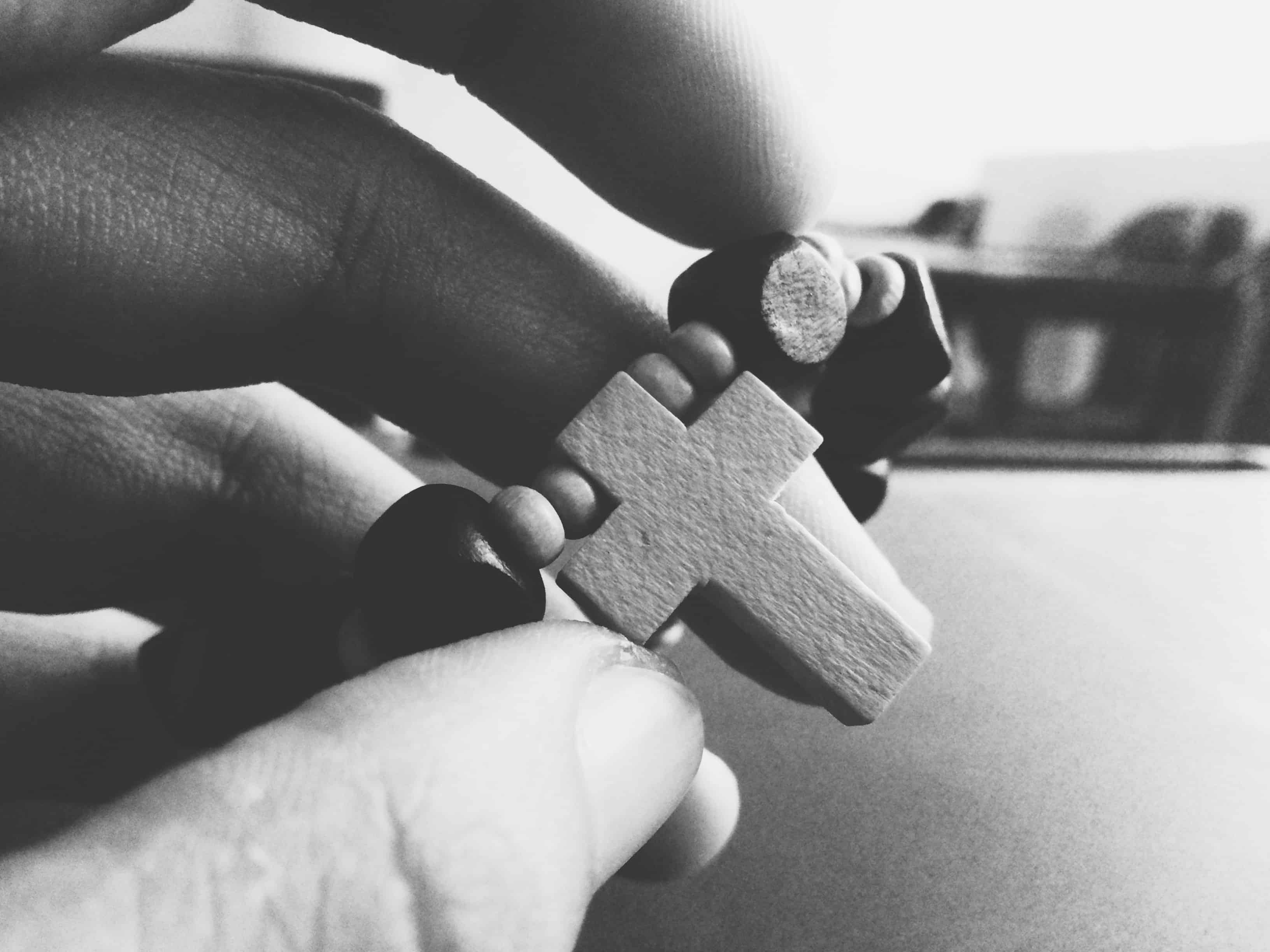 black and white photo of beads and cross